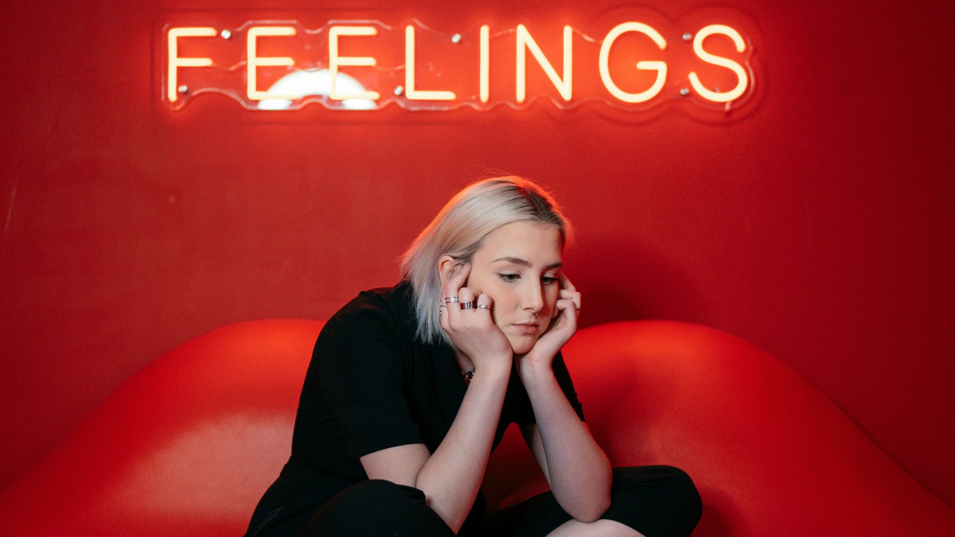 woman in black long sleeve shirt and black pants sitting on red couch