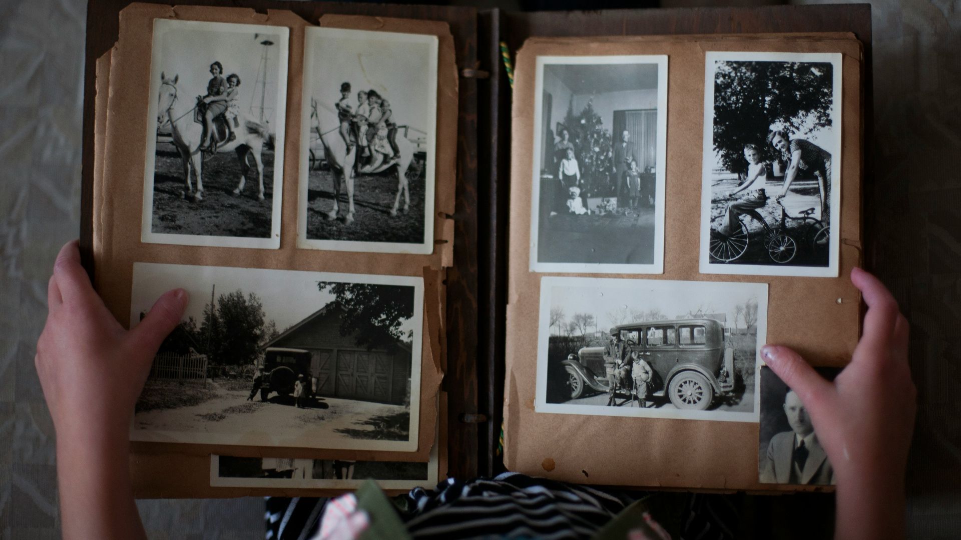 person opening photo album displaying grayscale photos