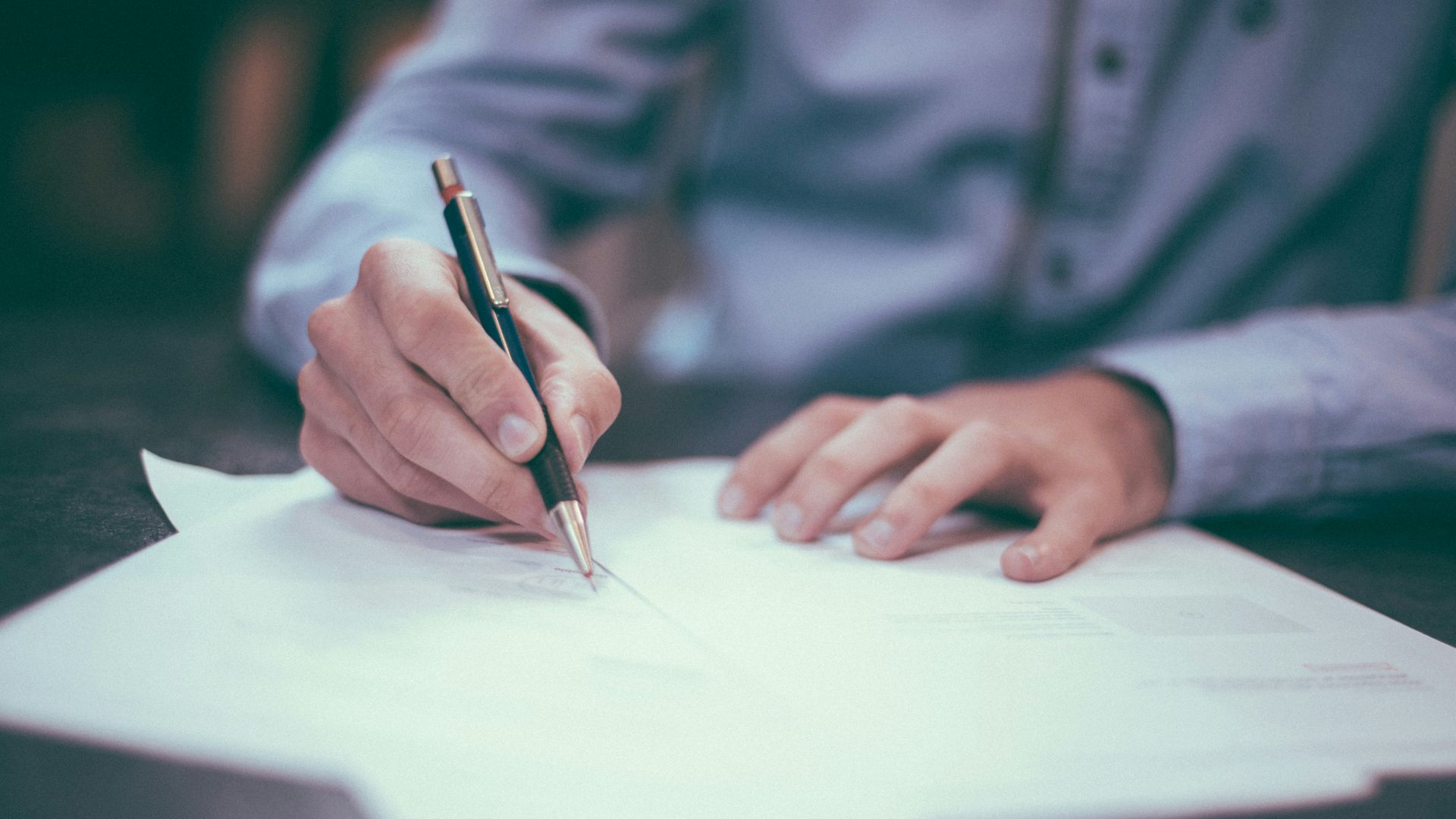 man writing on paper