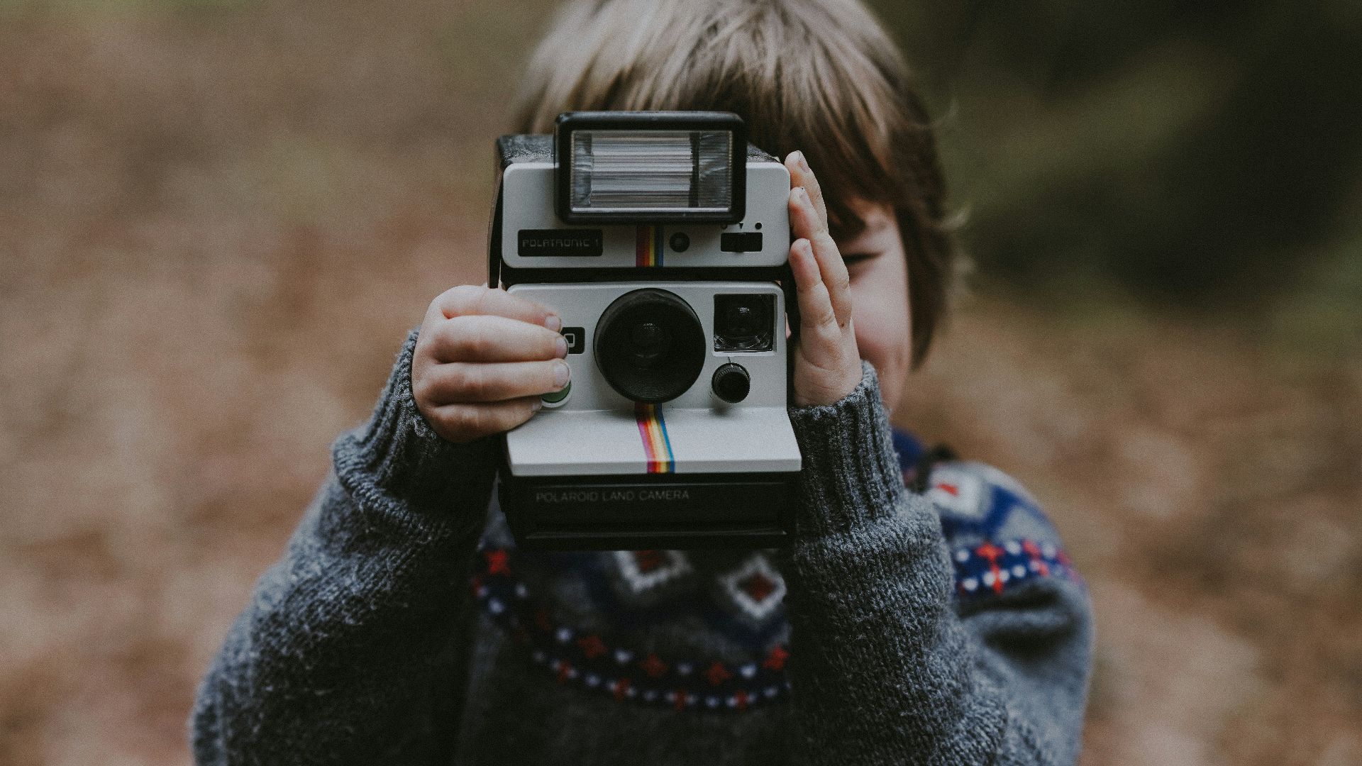 boy using white and black instant camera