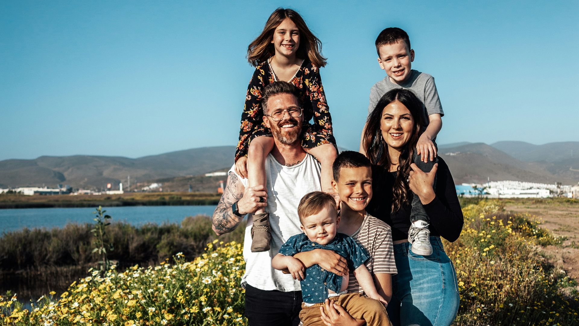 2 women and man standing on green grass field during daytime