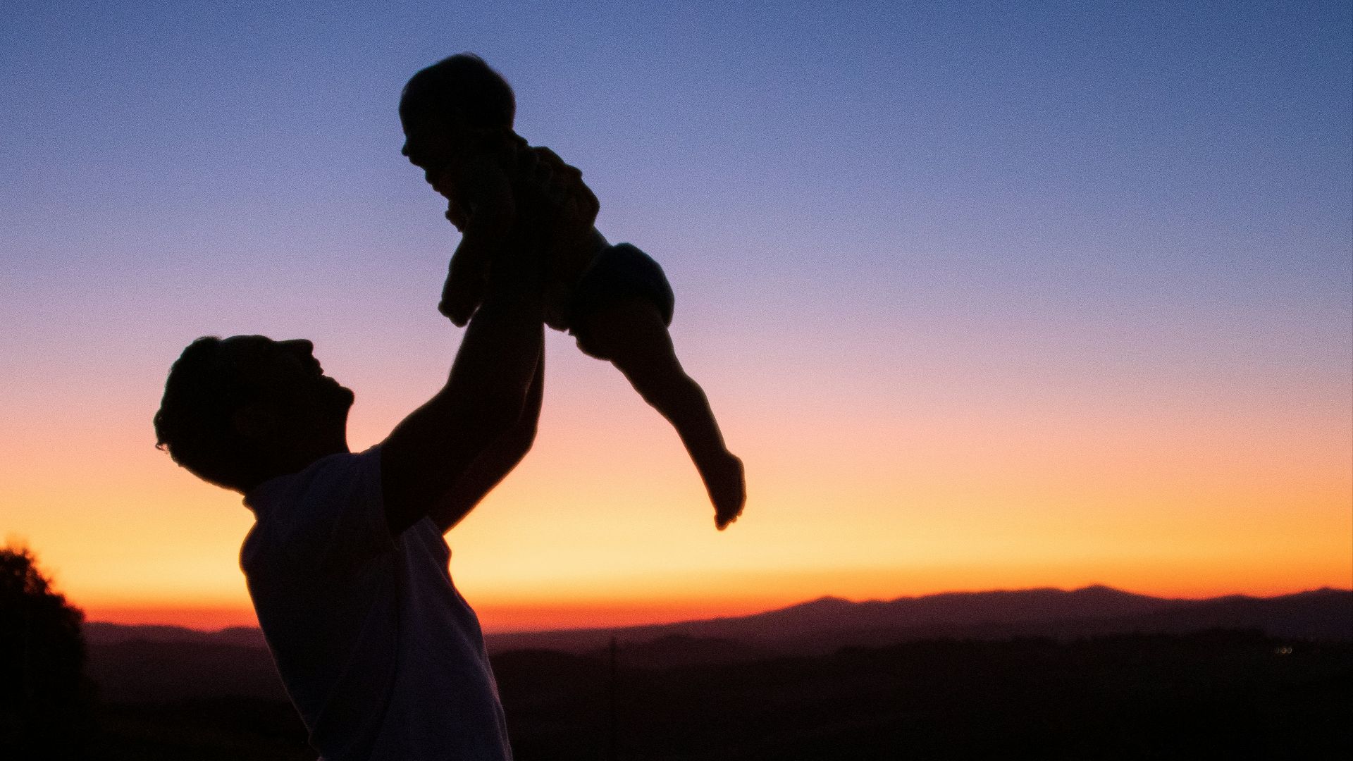 silhouette of man and woman kissing during sunset