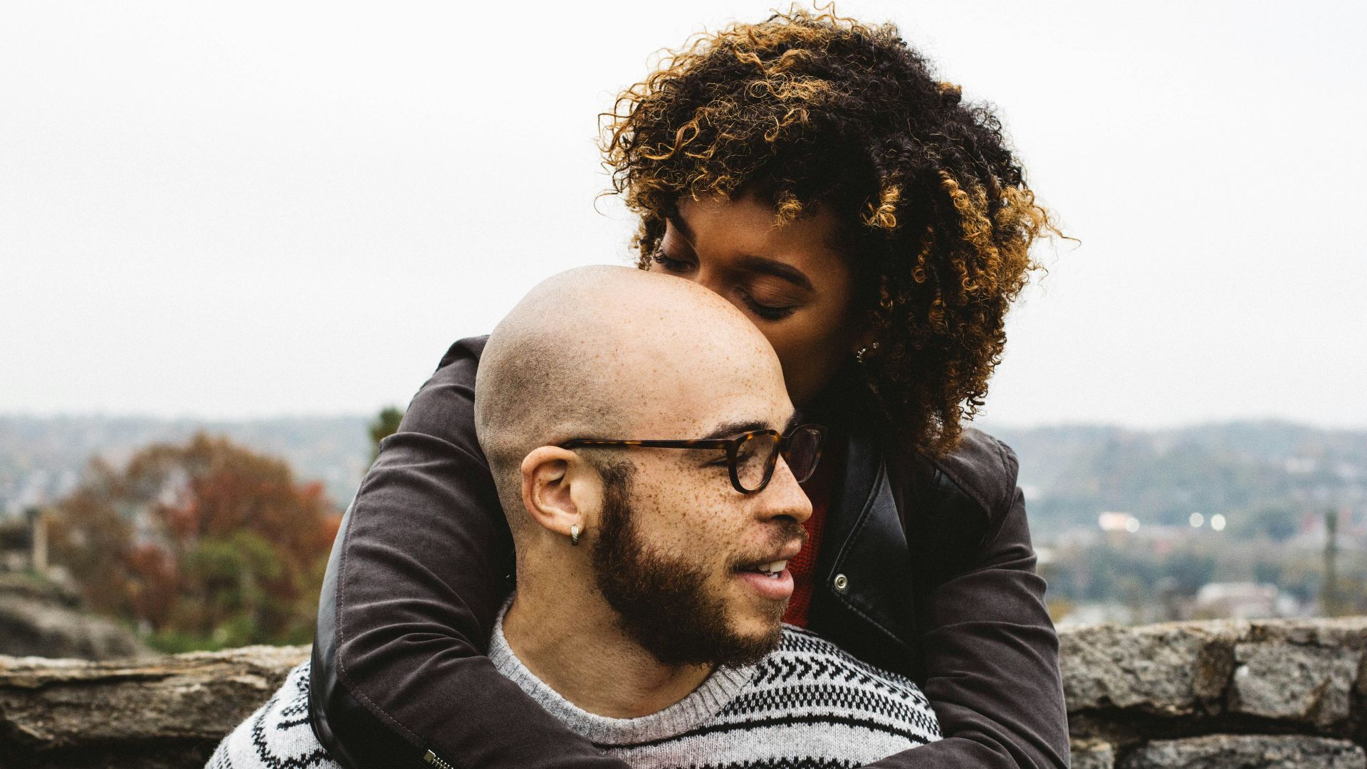 woman kissing man's head