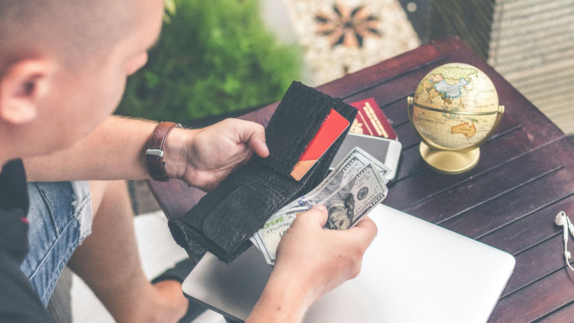 person holding wallet and US dollar bills