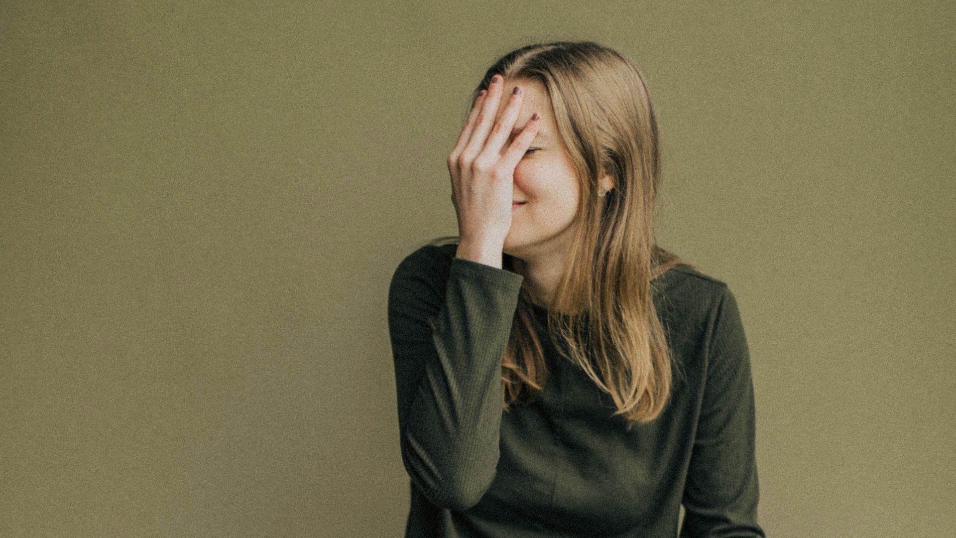 woman in black long sleeve shirt and blue denim jeans sitting on brown wooden chair