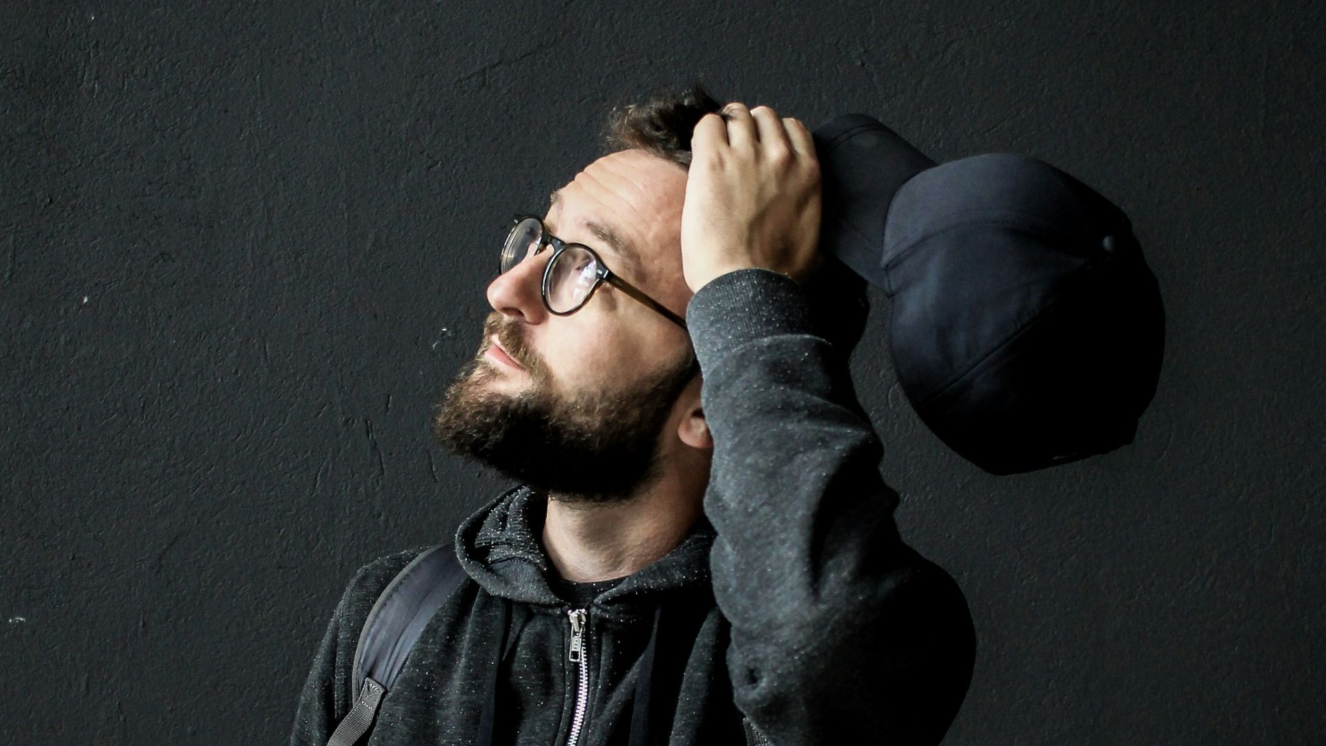 man looking up holding his hair