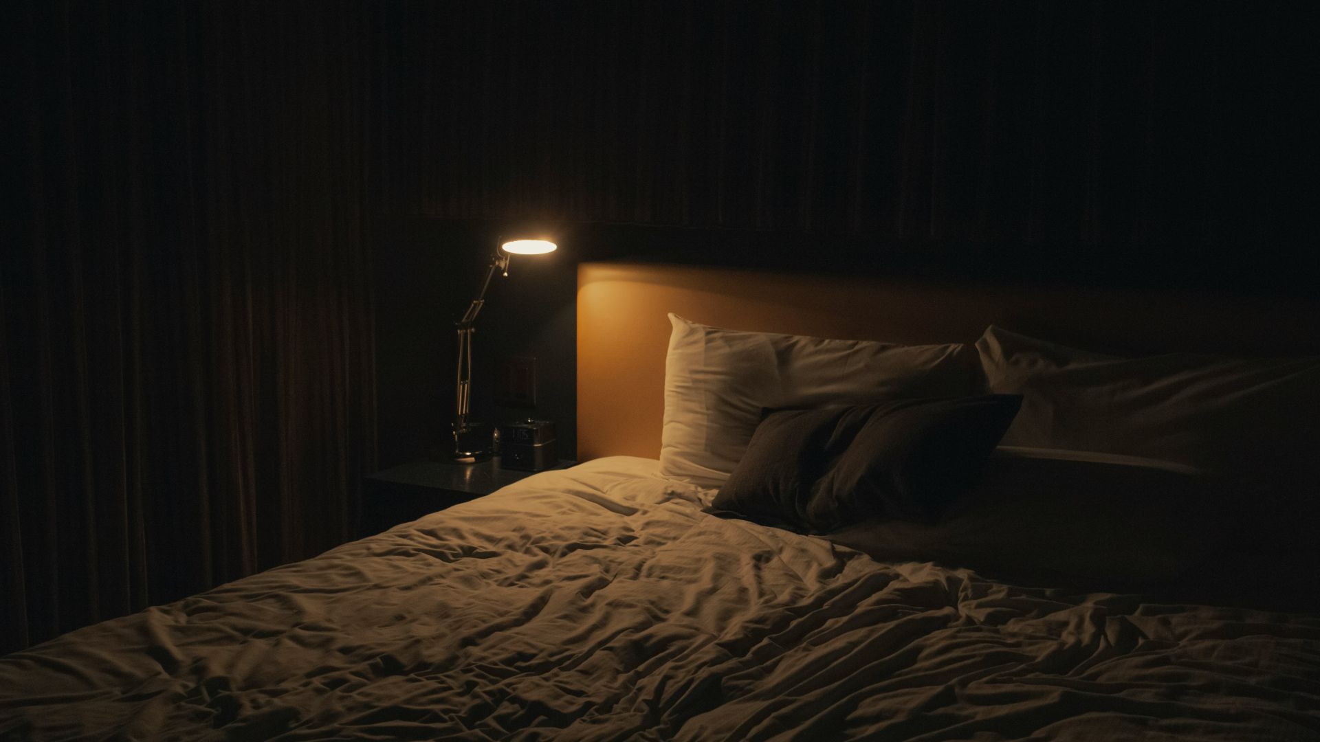 table lamp turned-on near bed