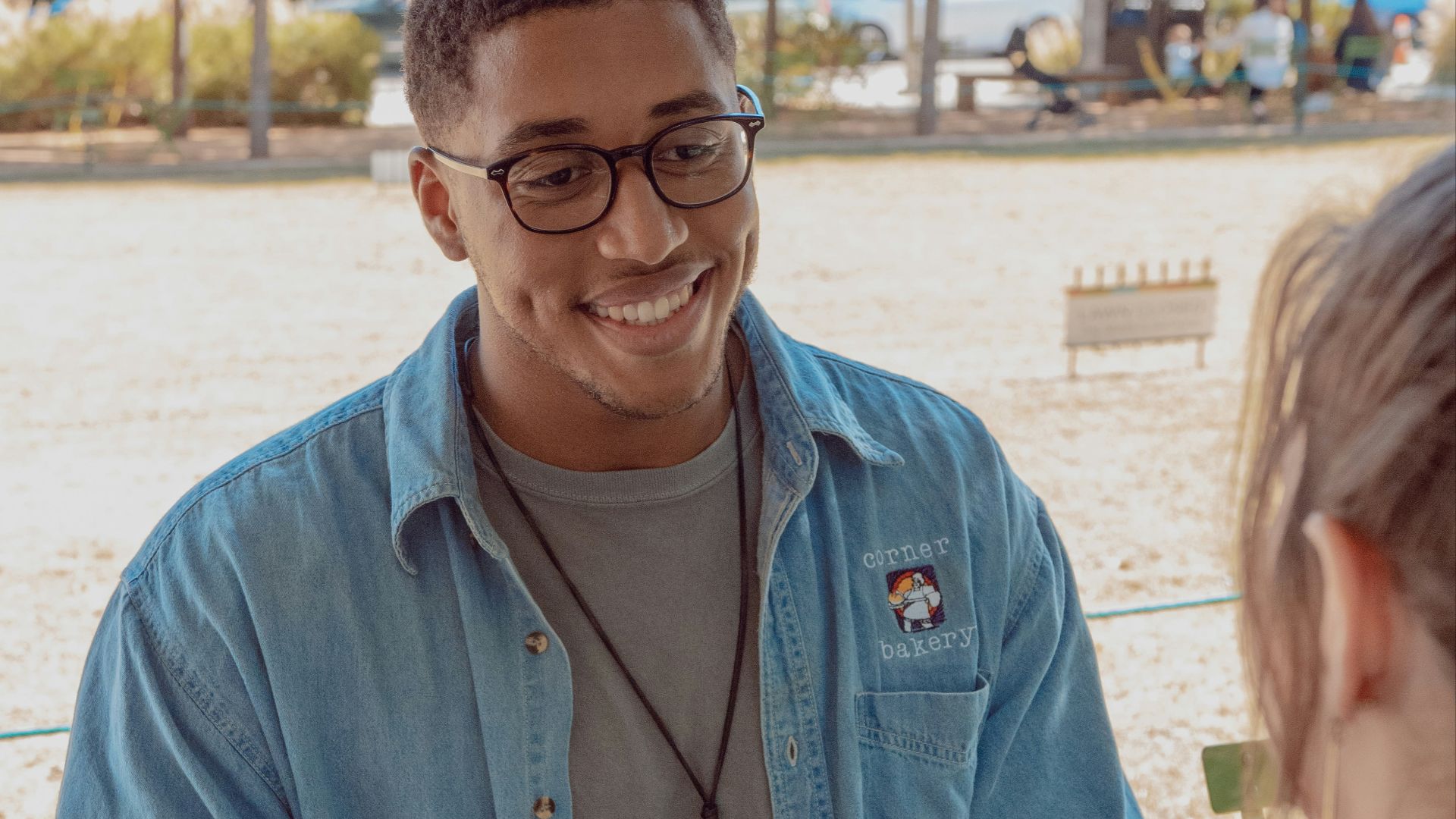 man wearing blue denim button-up shirt facing on human