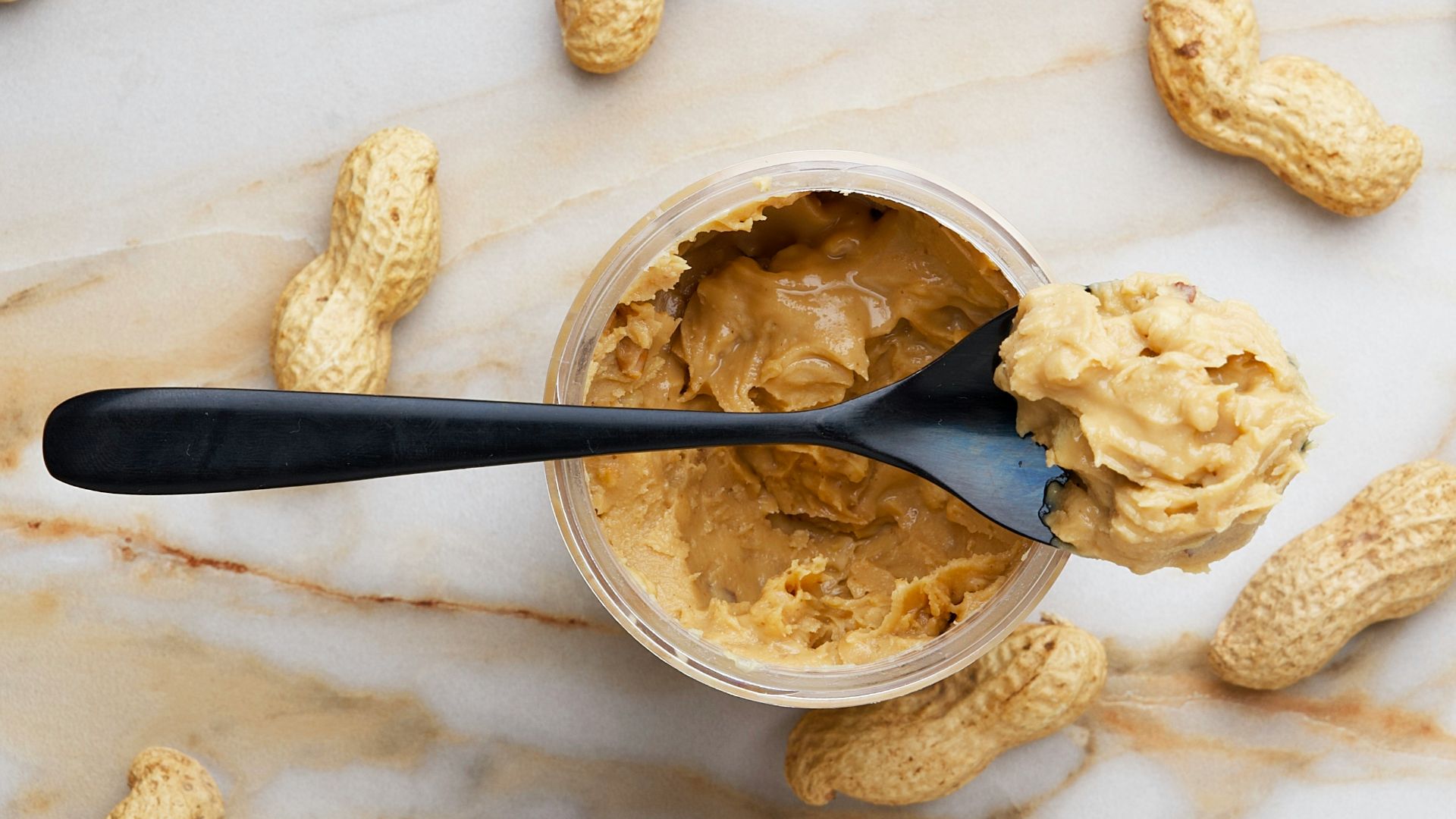 peanut butter with black spoon