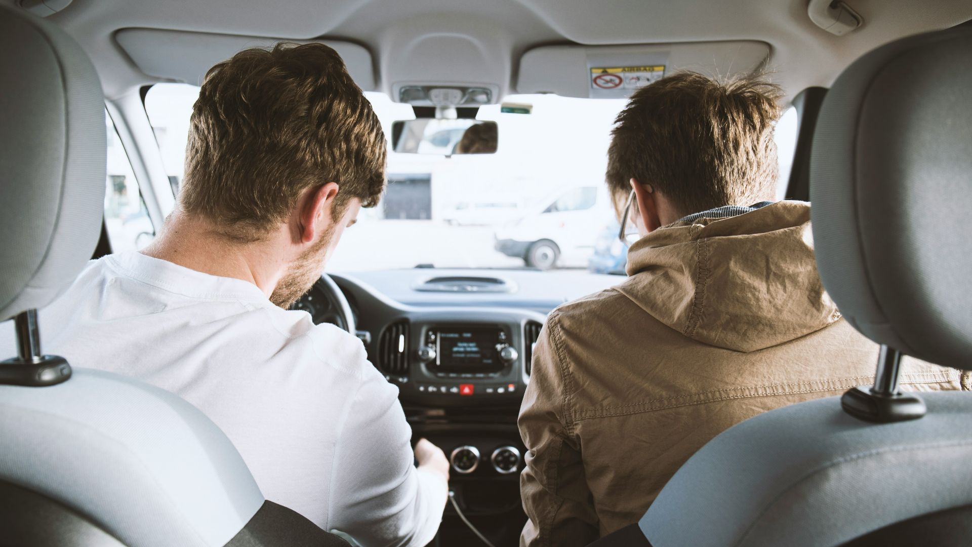 two men sitting inside vehicle