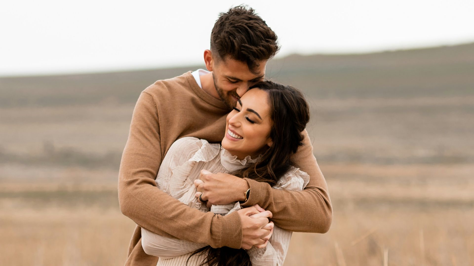 A man and a woman hugging in a field