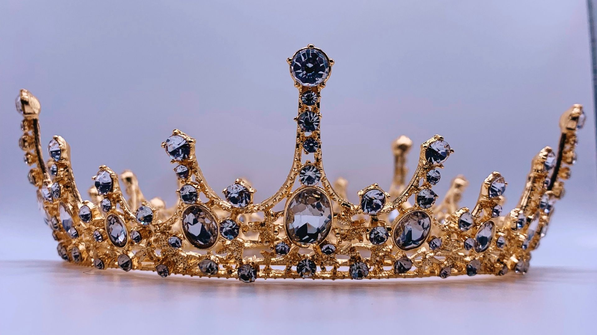 a gold crown with black and white stones