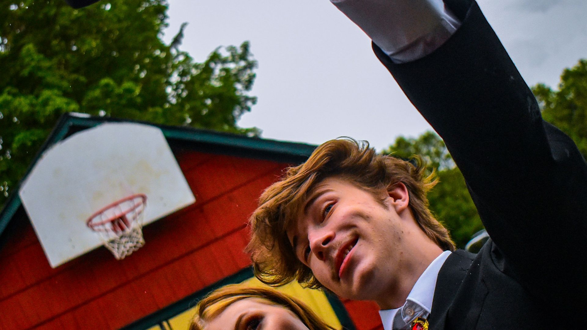 man in black suit jacket holding smartphone
