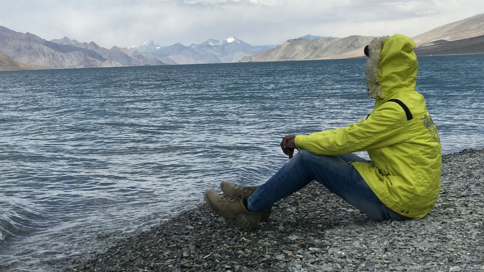 man sitting in front of body of water