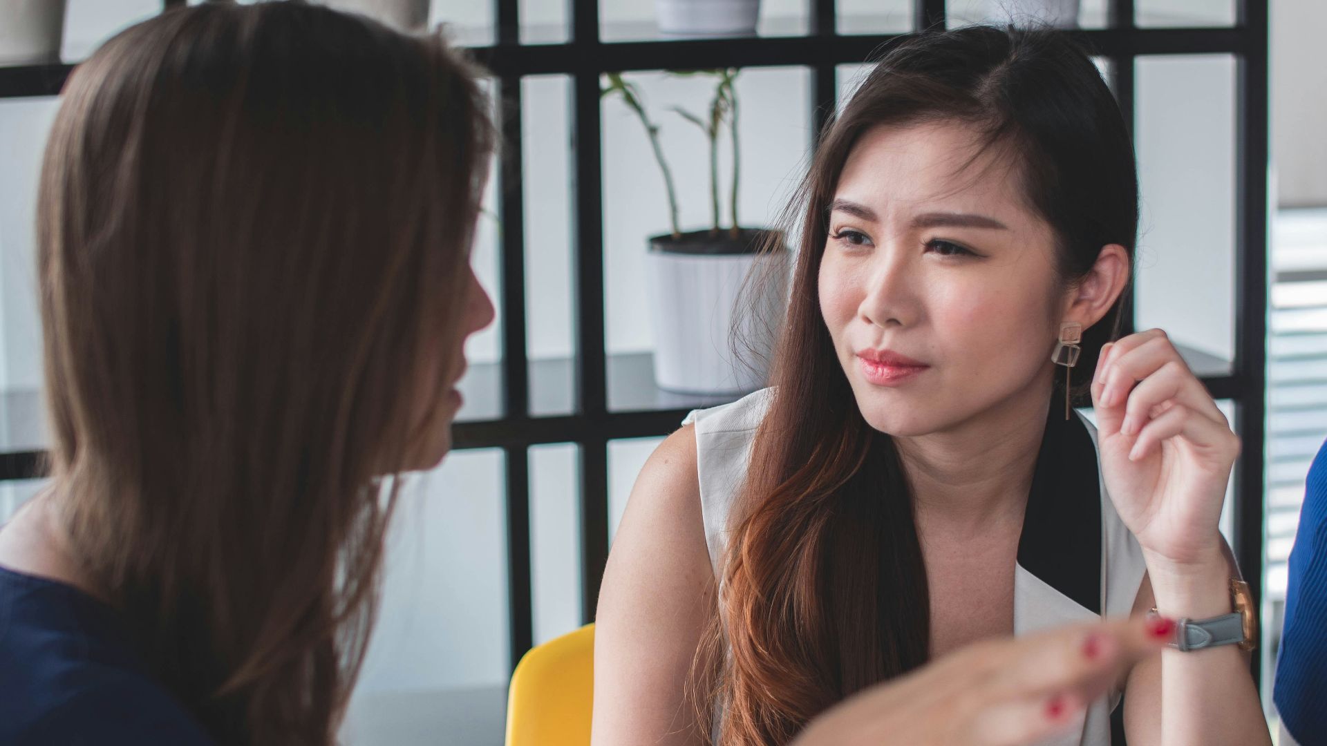 woman sitting on yellow armless chair near gray laptop computer