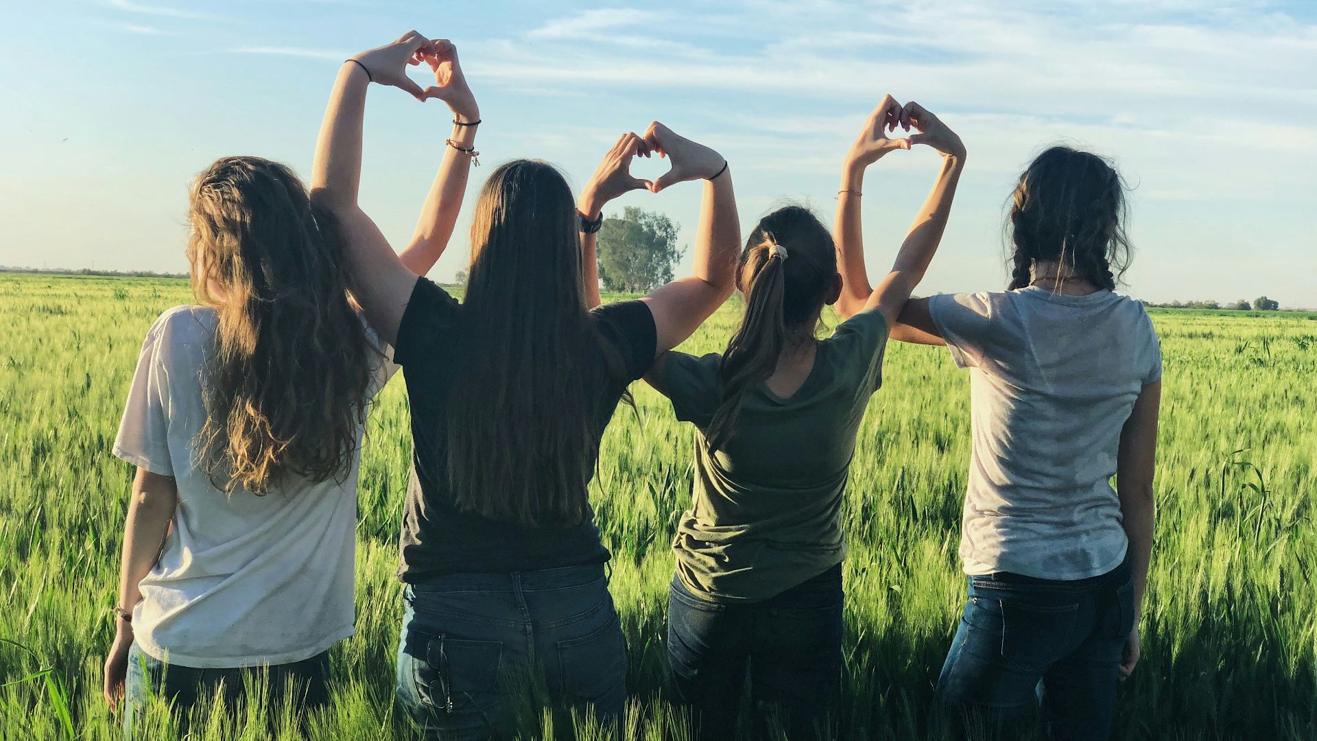women forming heart gestures during daytime