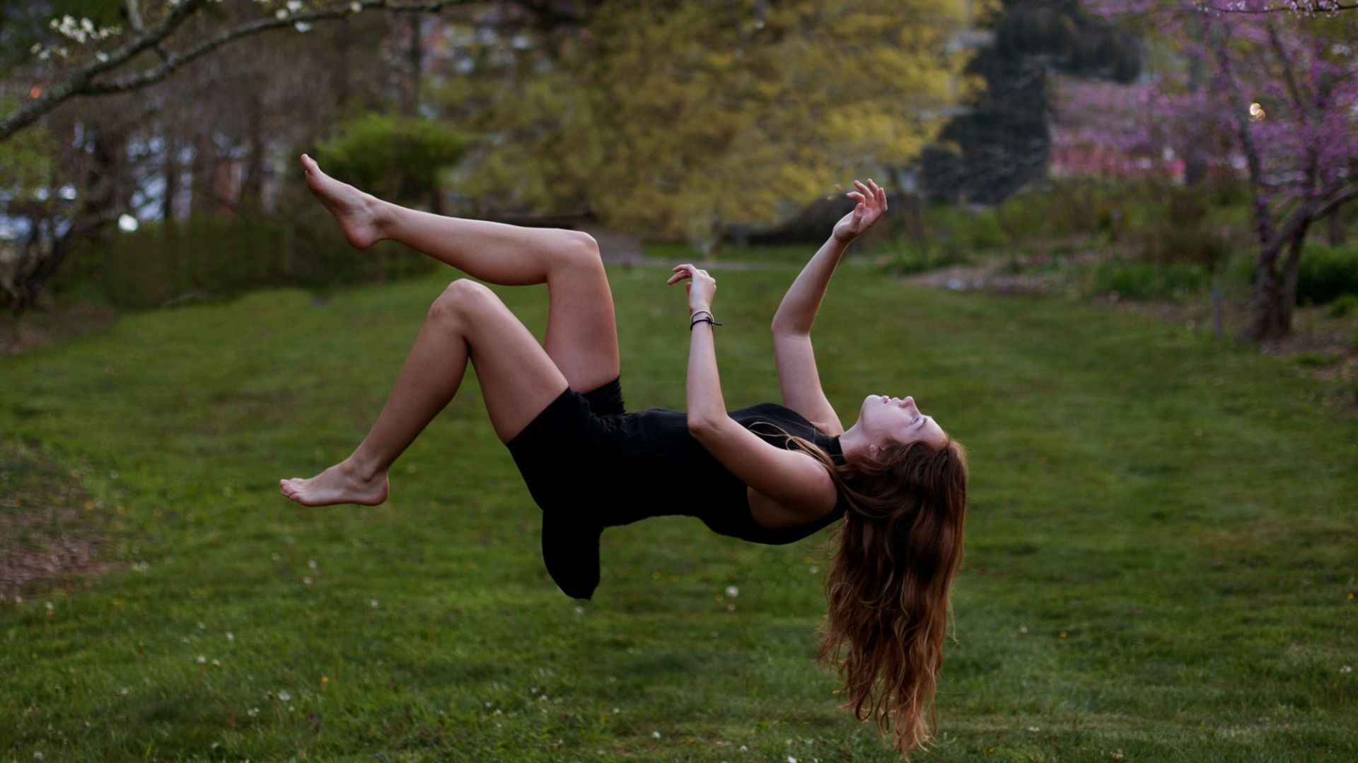 woman back flipping in the garden
