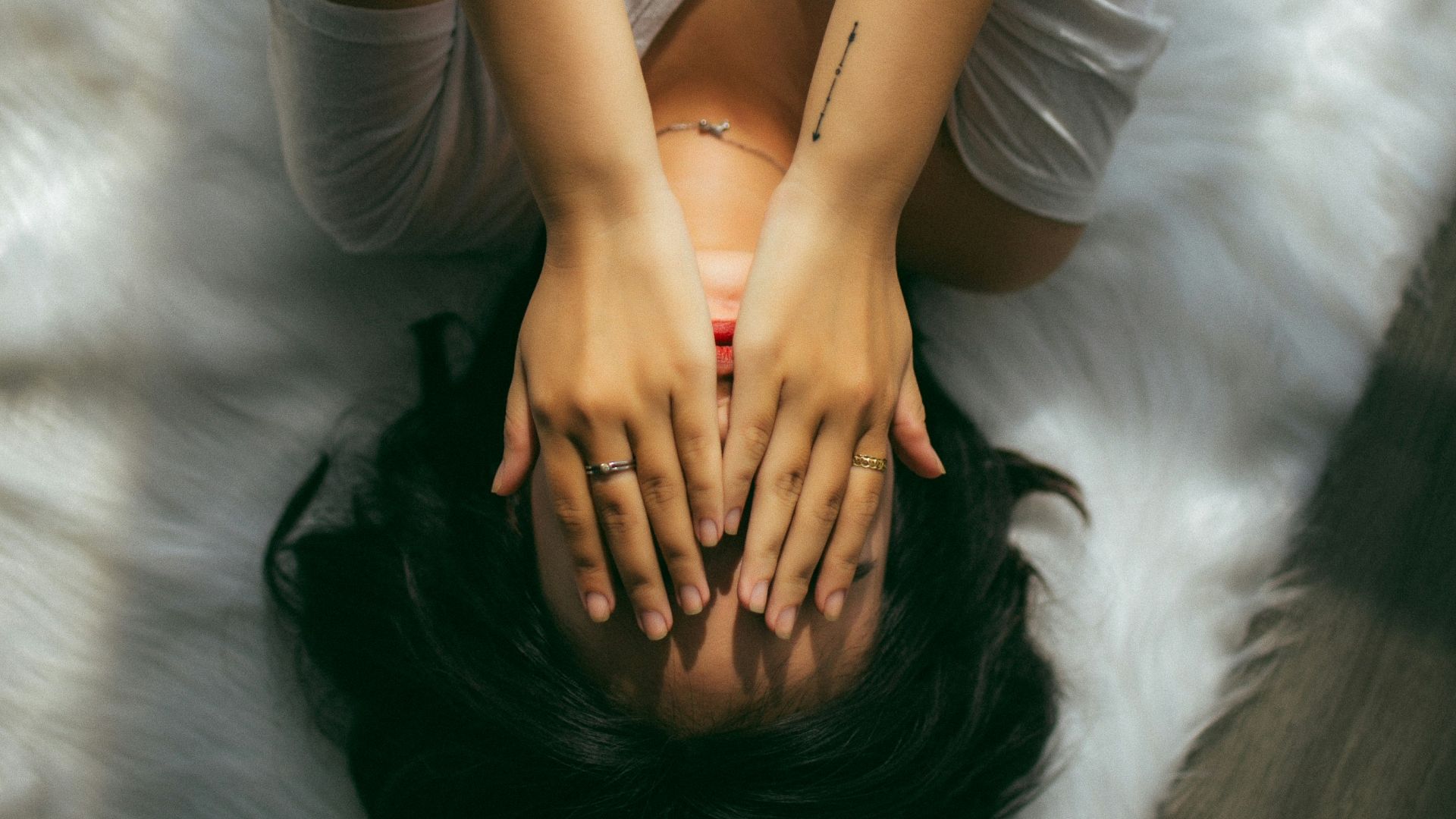 a woman holds her hands over her face