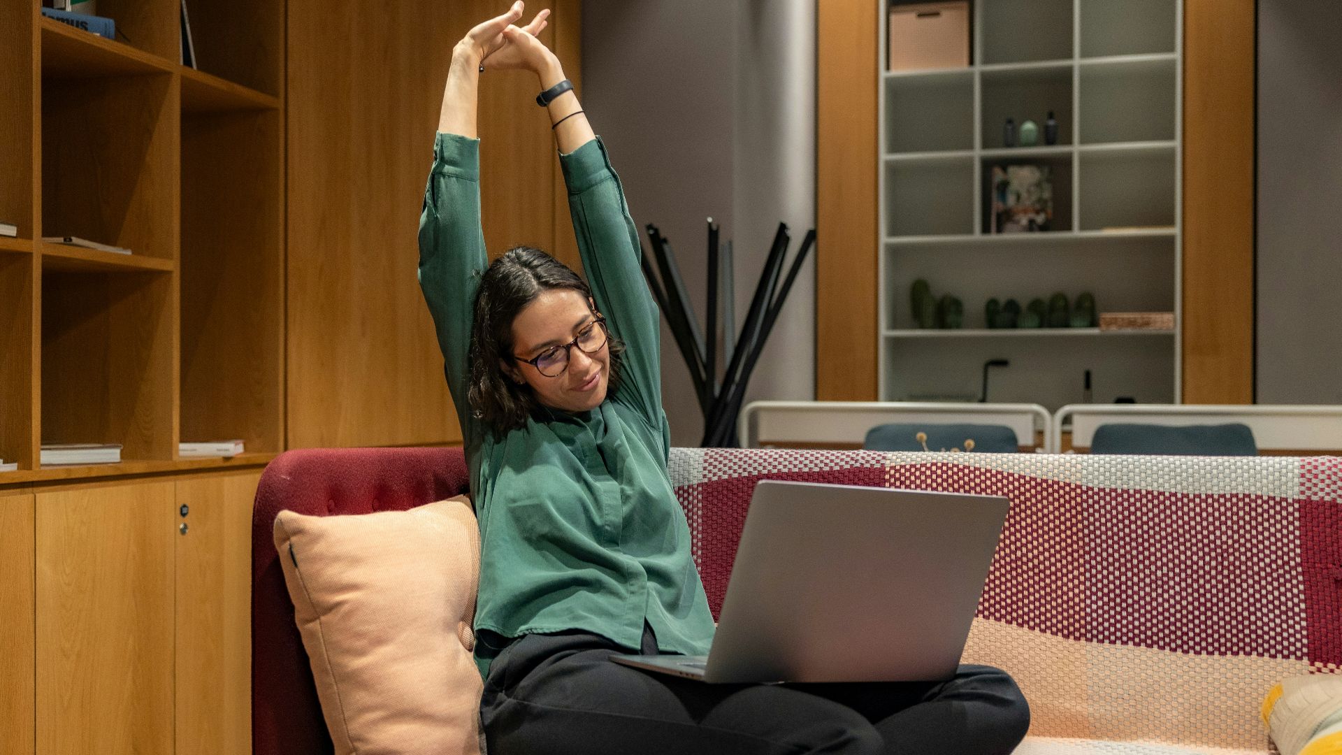 a woman sitting on a couch using a laptop