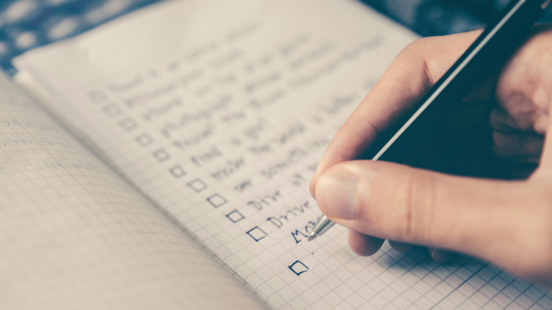 person writing bucket list on book