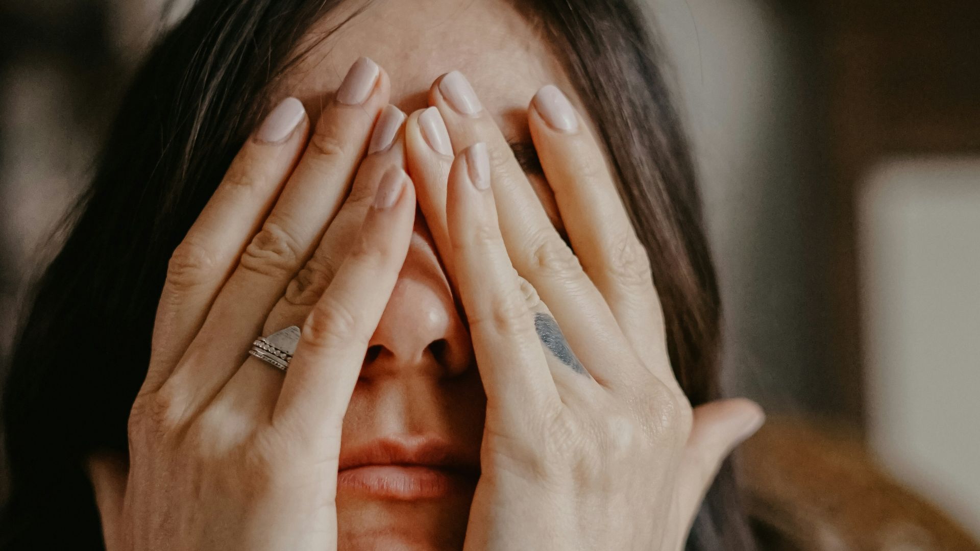woman in black long sleeve shirt covering her face