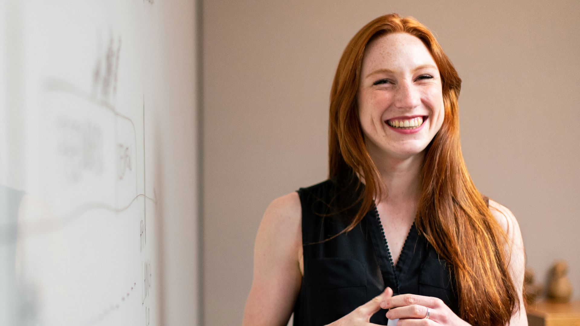 woman in blue tank top standing beside white wall