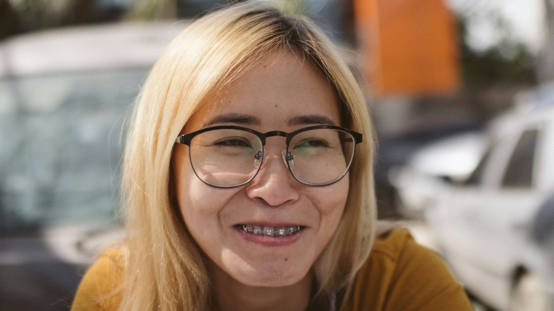 a woman with glasses and a smile on her face