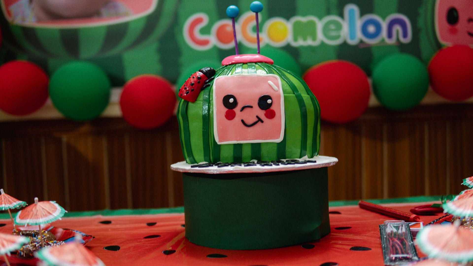 A cocomelon themed cake is displayed.