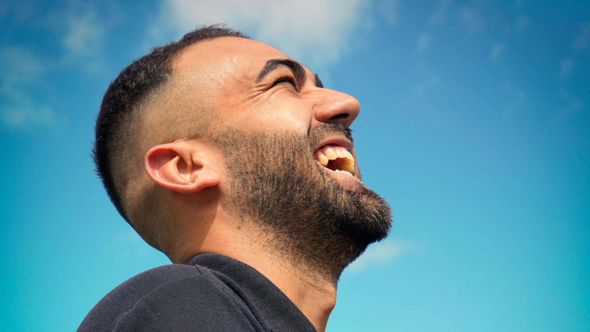 smiling man wearing black collared top