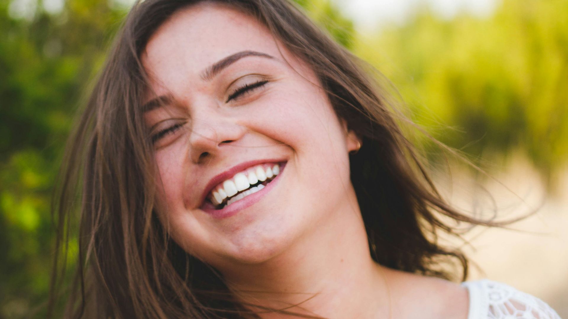 woman smiling wearing white top