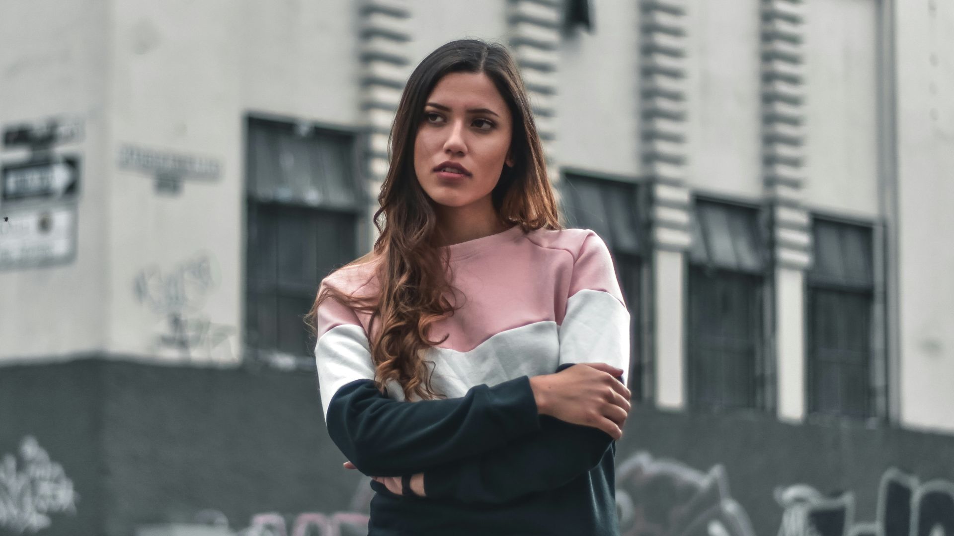 woman standing beside black and gray concrete building