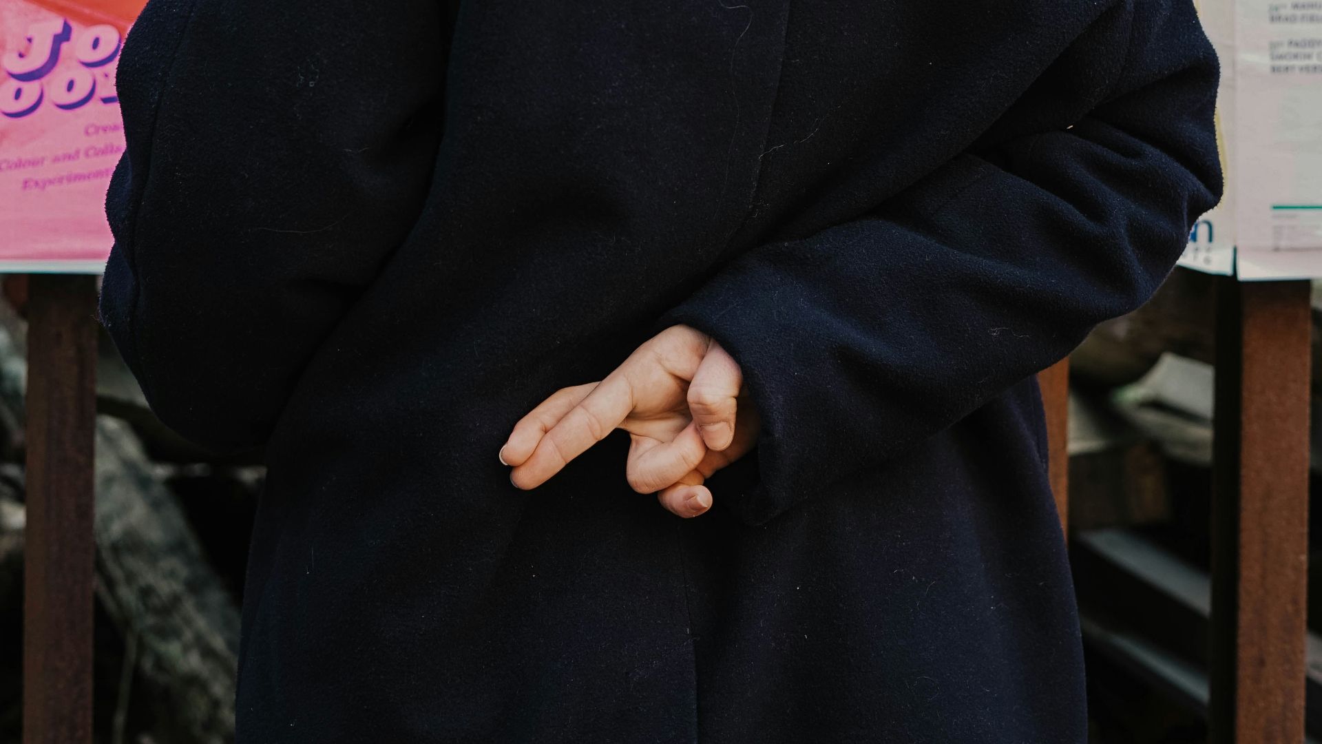 woman in blue hoodie standing in front of white and red kanji text signage