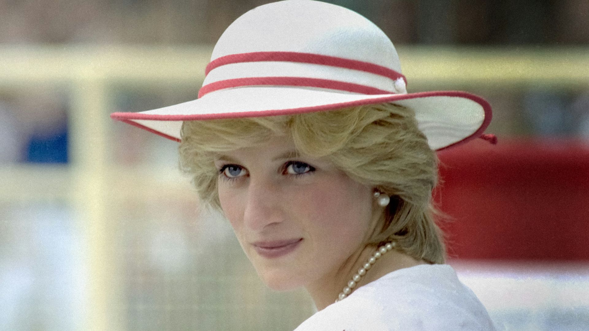 a woman in a red and white dress and hat