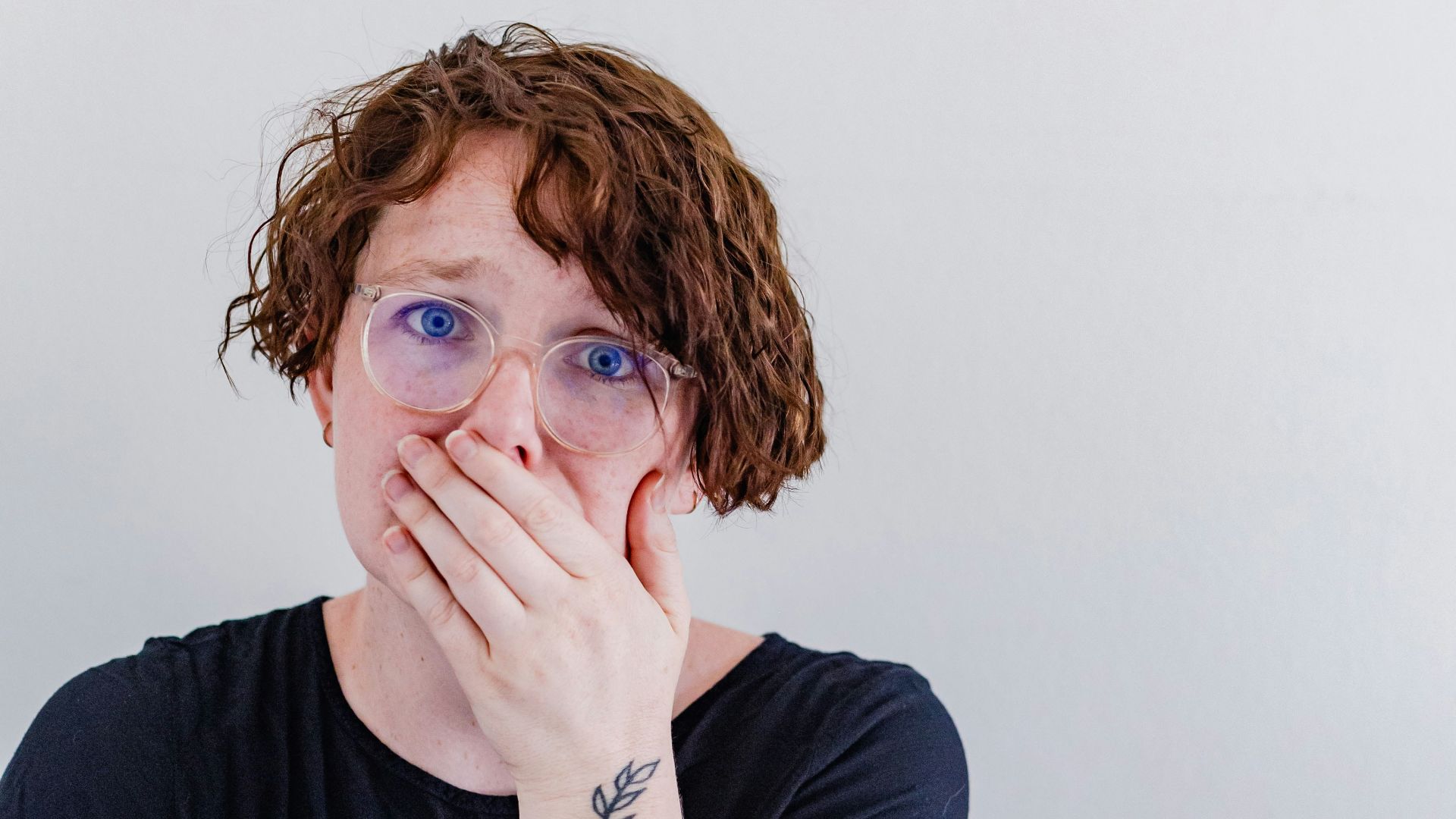 a woman covers her mouth with her hands