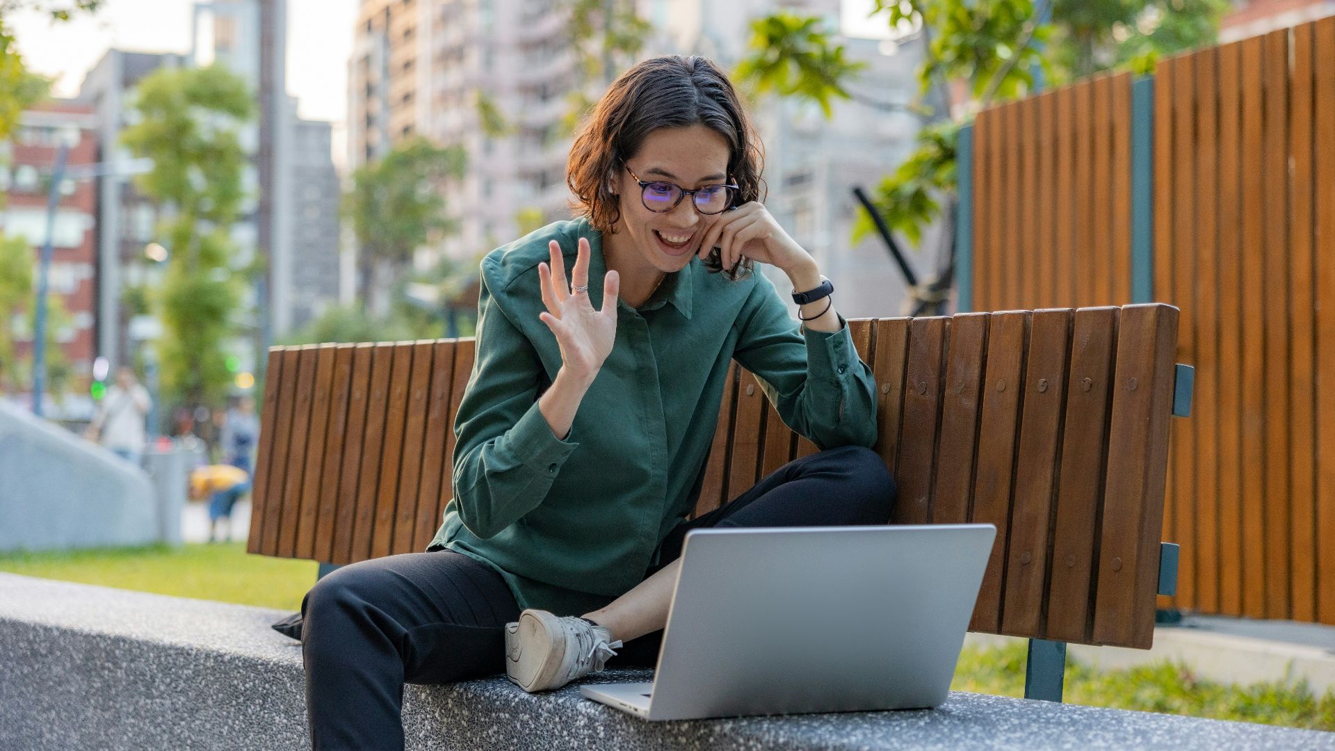 a woman sitting on a bench with a laptop