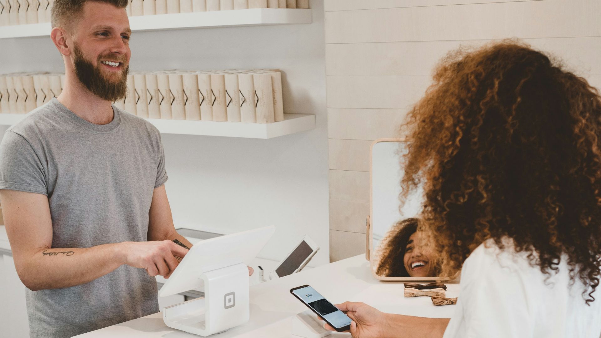 man in grey crew-neck t-shirt smiling to woman on counter