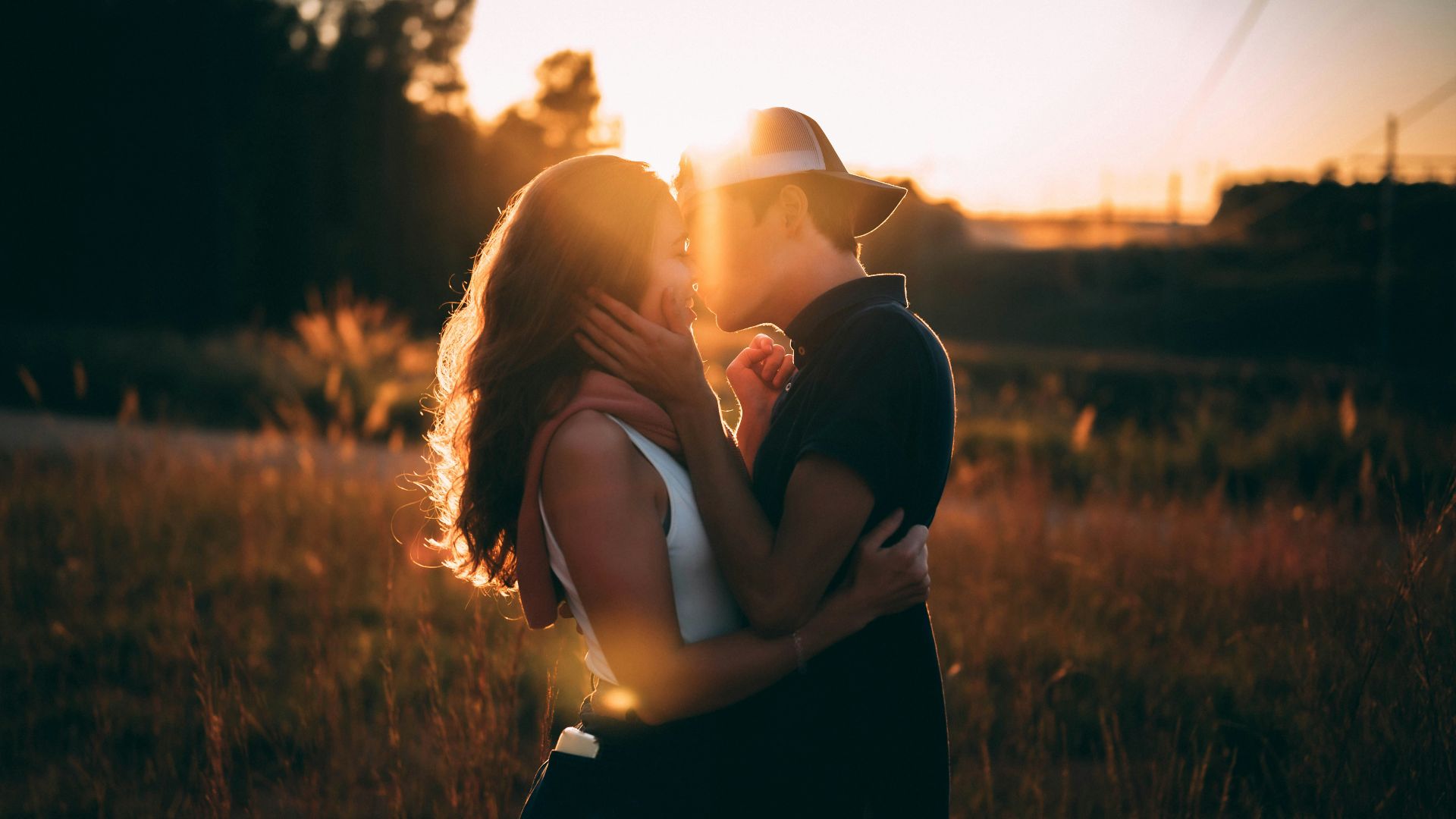 man and woman kissing during sunset