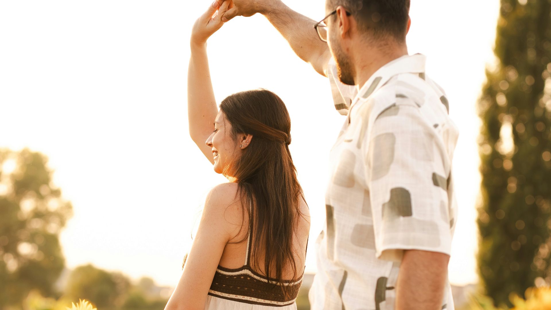 A couple dances in a sunflower field.