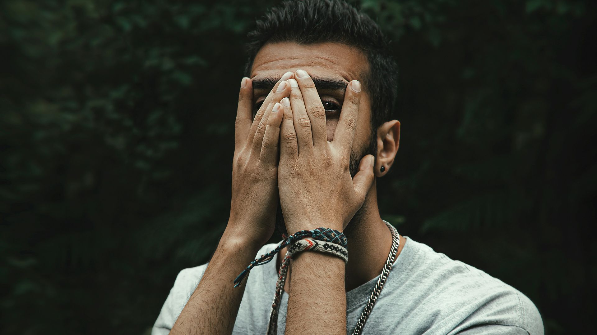 a man covering his eyes with his hands