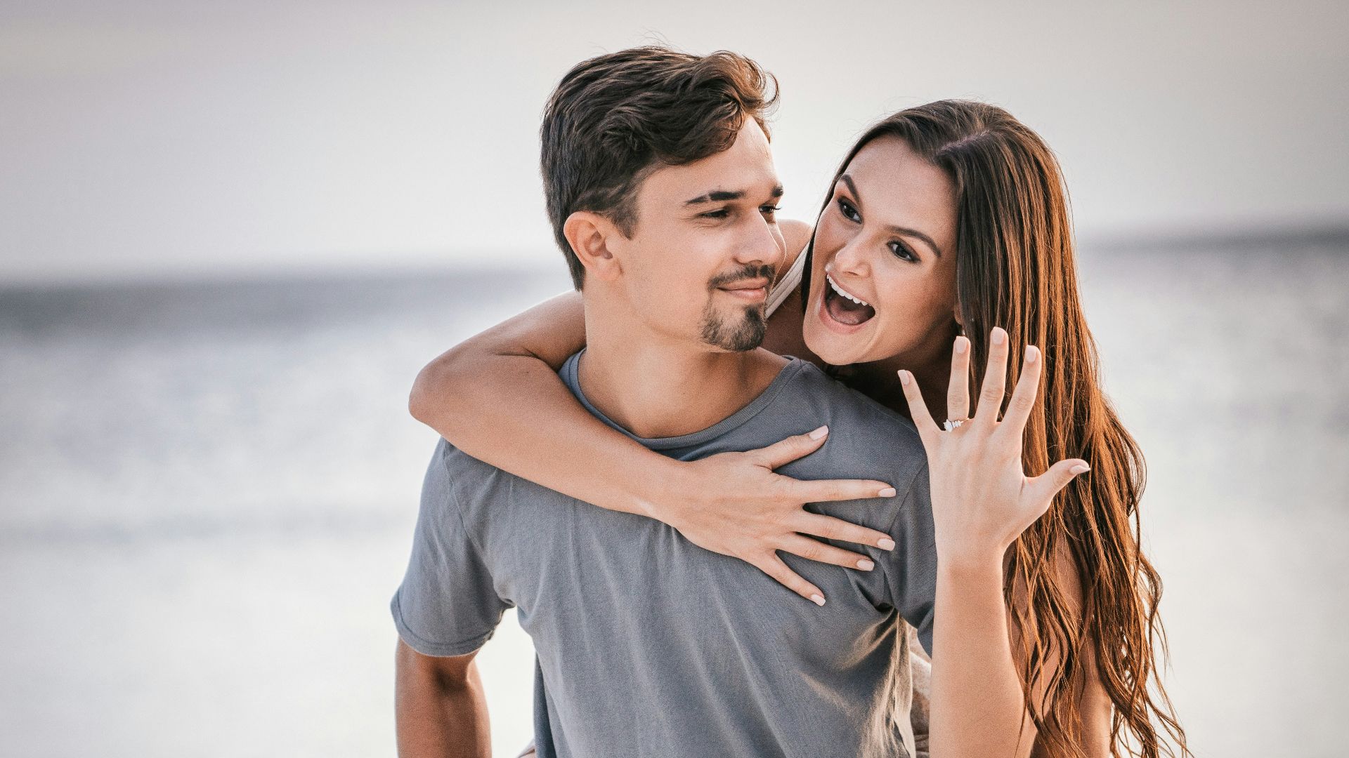 man in white crew neck t-shirt hugging woman in blue denim shorts