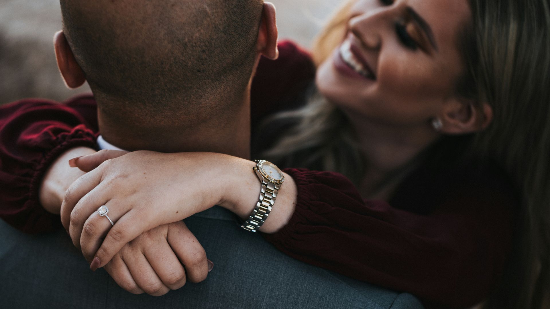 man in black suit jacket kissing woman in red shirt