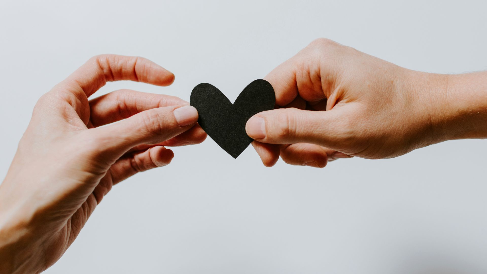 two person holding papercut heart
