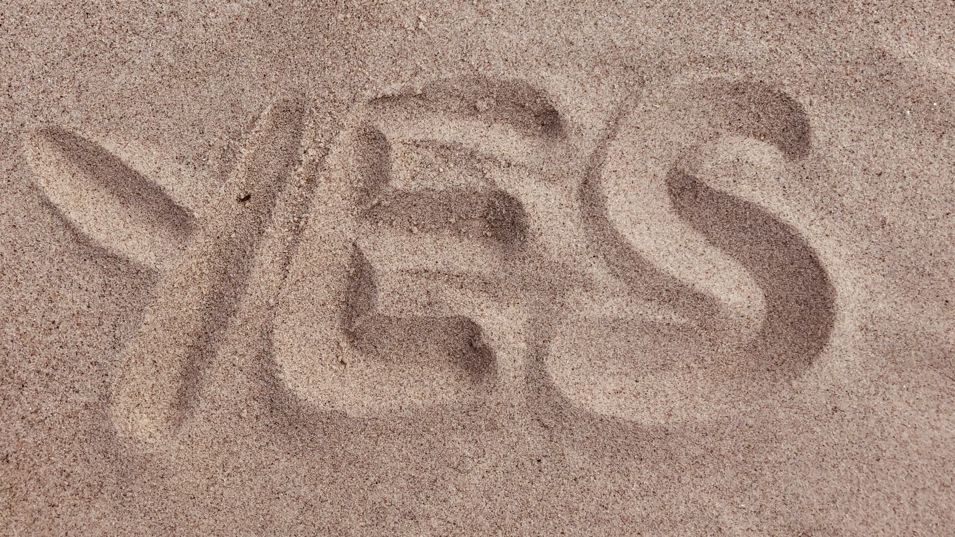 yes text on brown sand