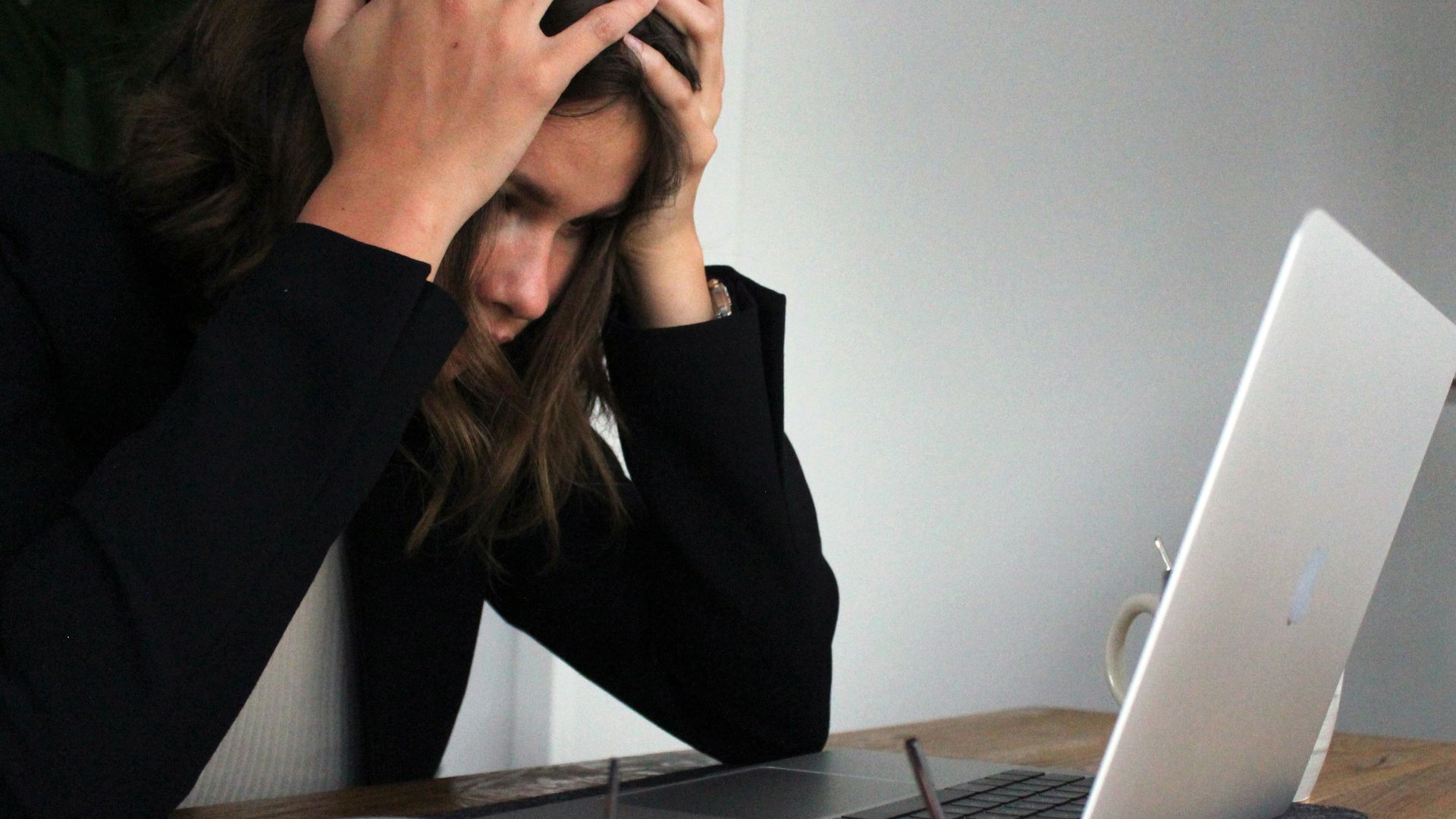 a woman sitting in front of a laptop computer