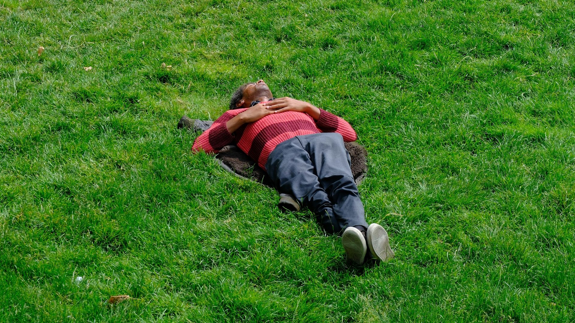 A person lies in grass.