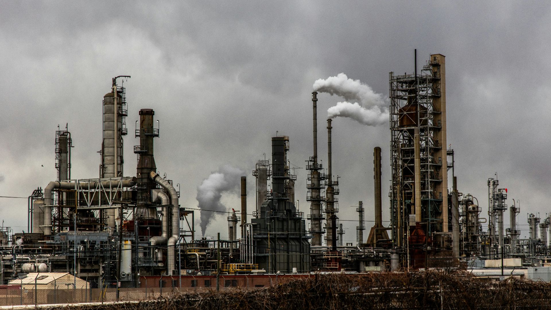 factories with smoke under cloudy sky