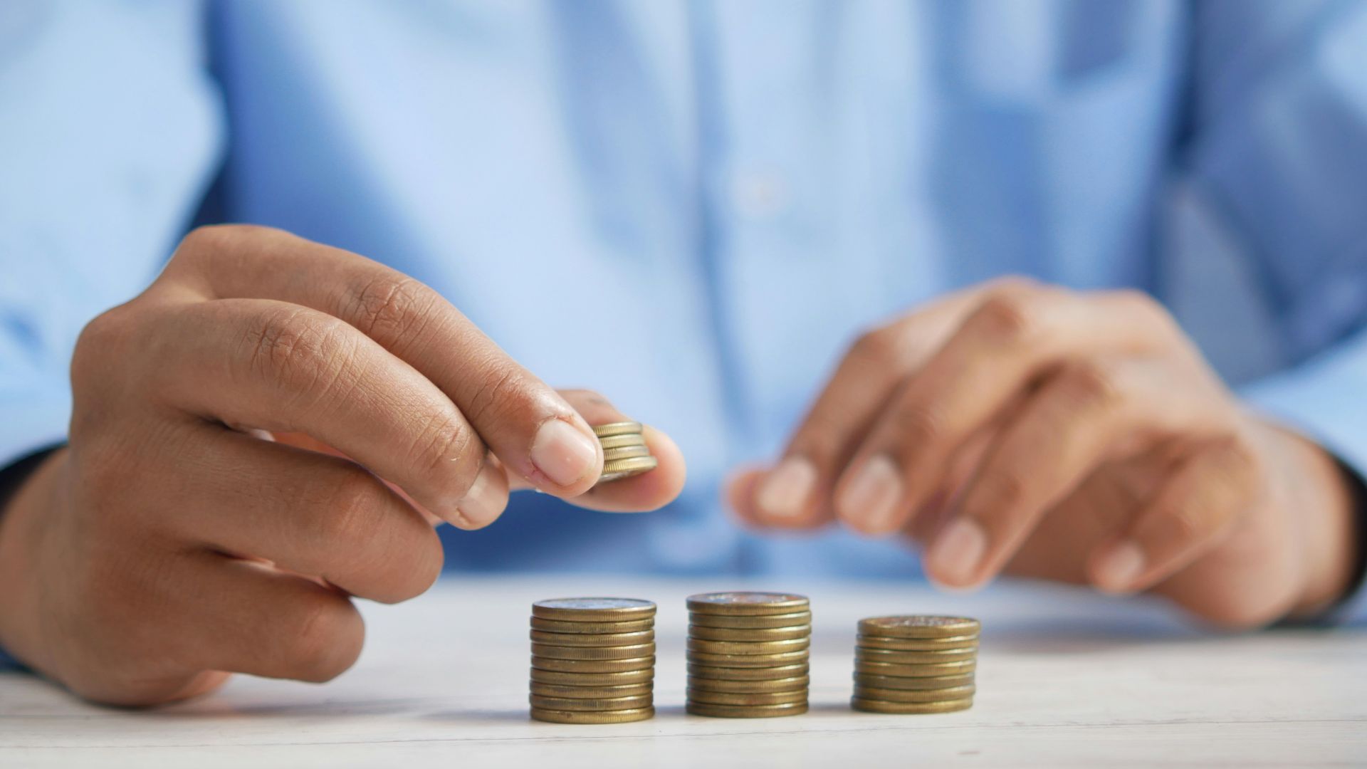 a person stacking coins on top of a table