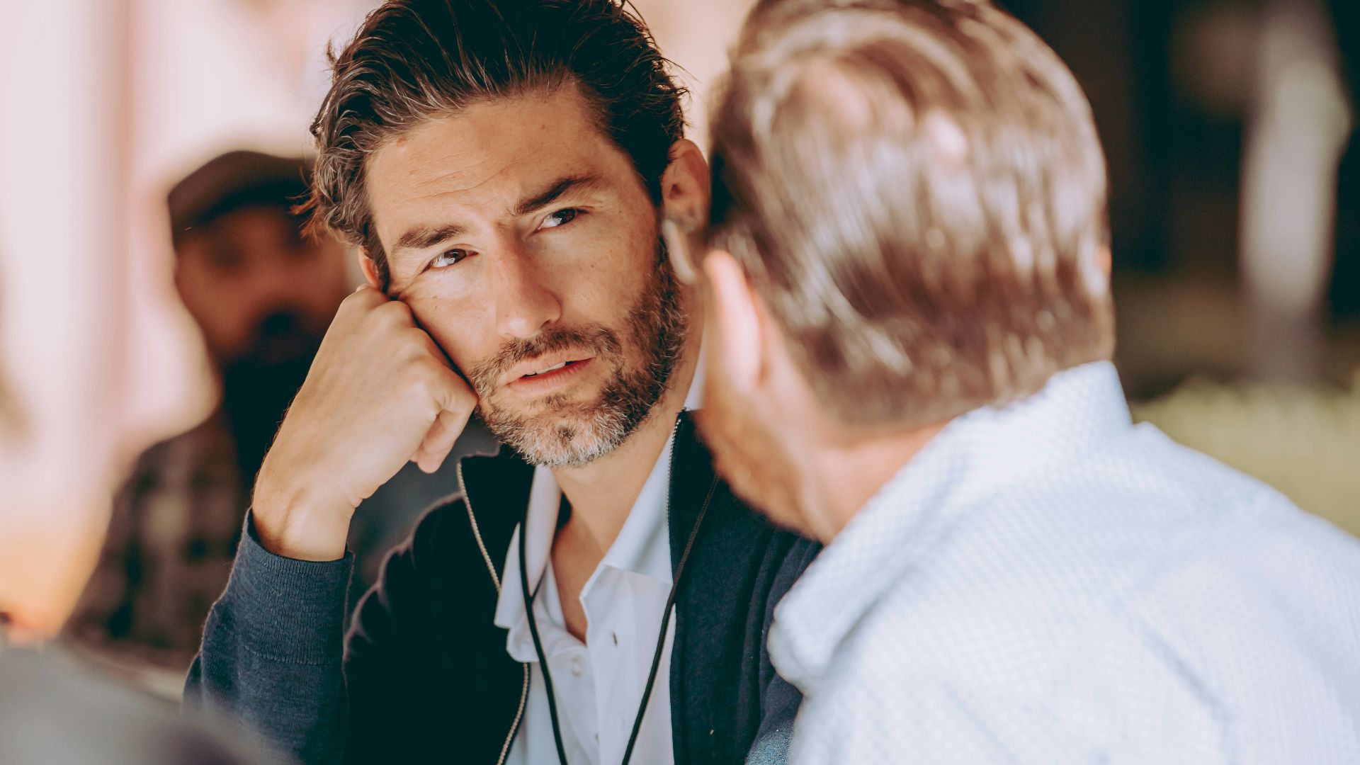 two men sitting at a table talking to each other