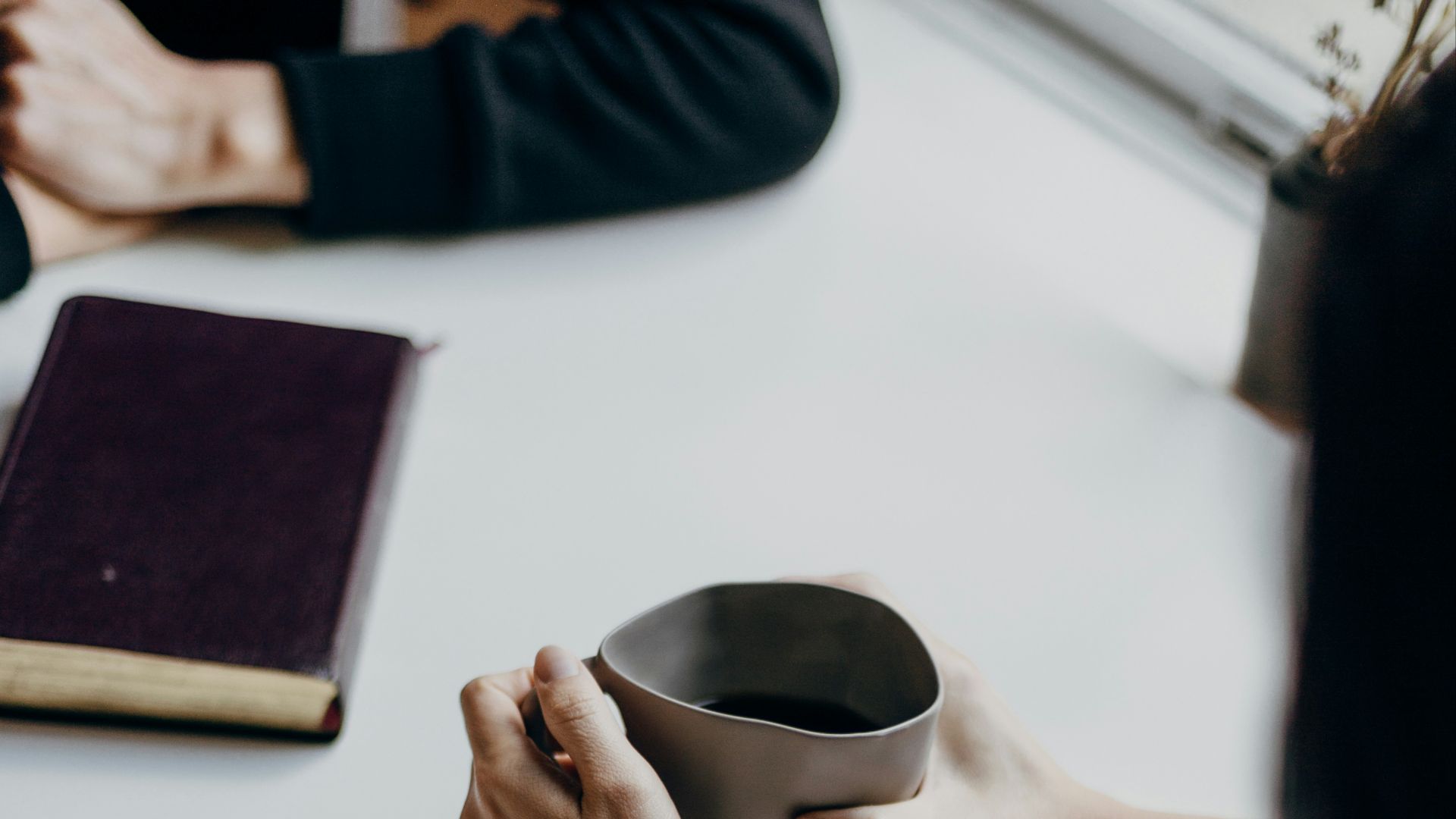 woman in white sweater holding black round frame