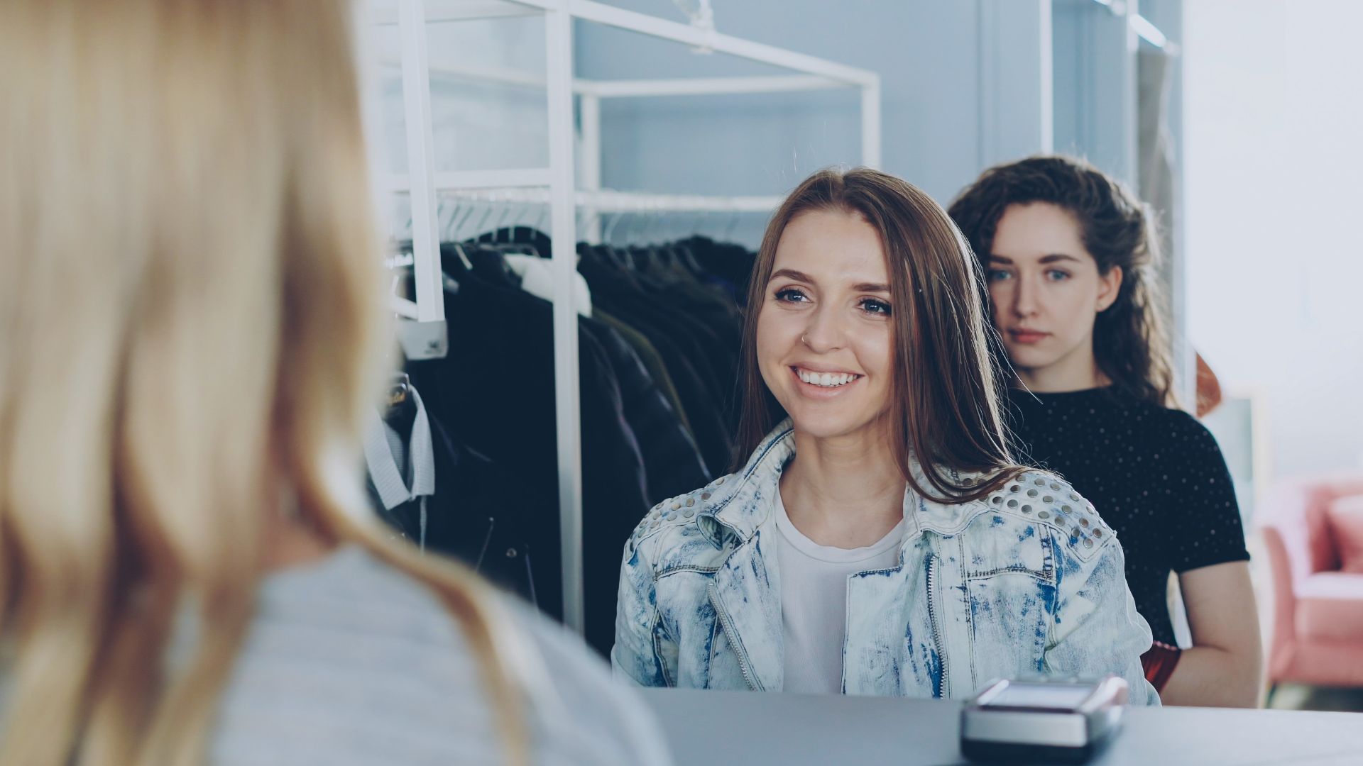 Customers interact with a cashier at a store.